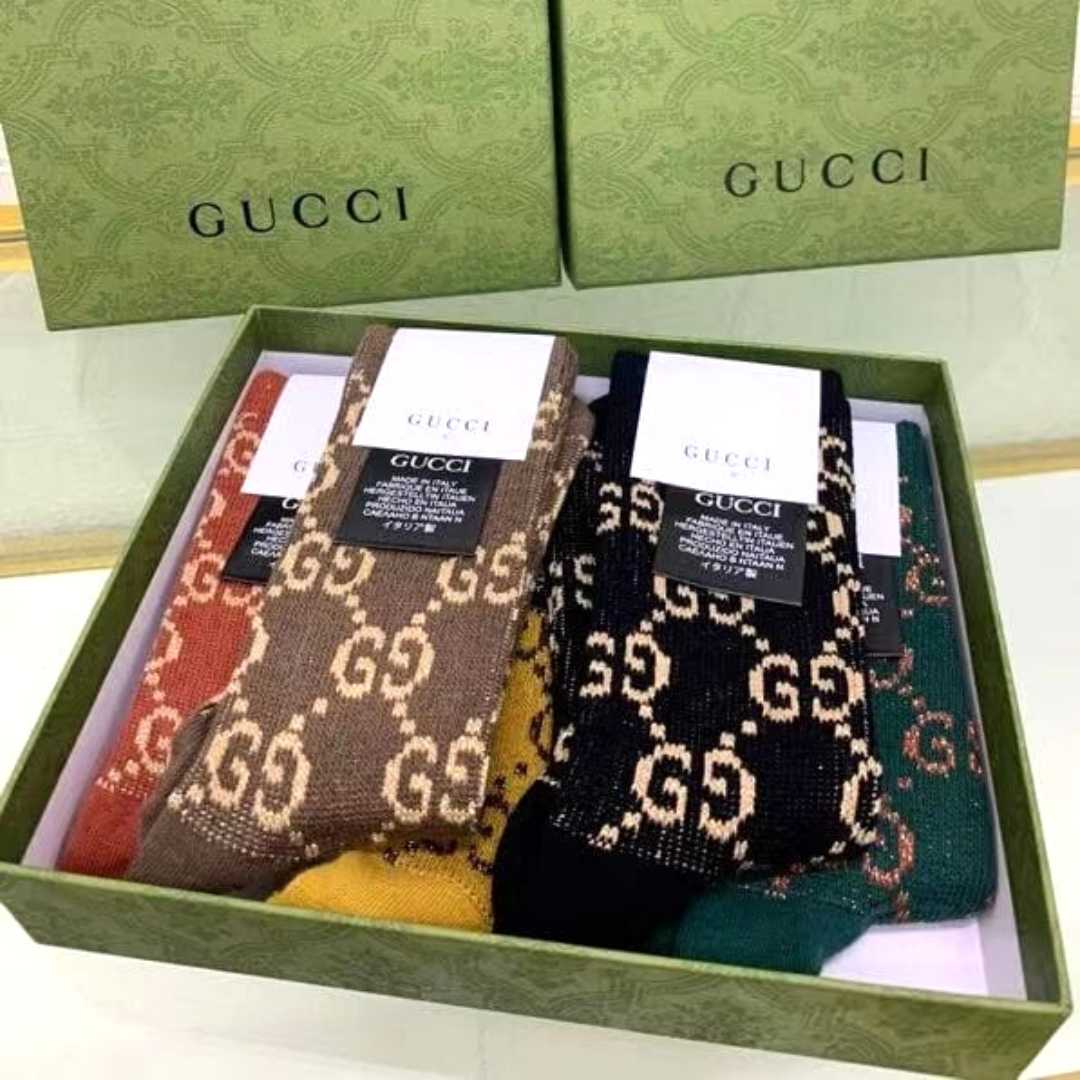 Brown, black, green, yellow, and red Gucci kids socks with metallic gold Gucci logo and chain lines
